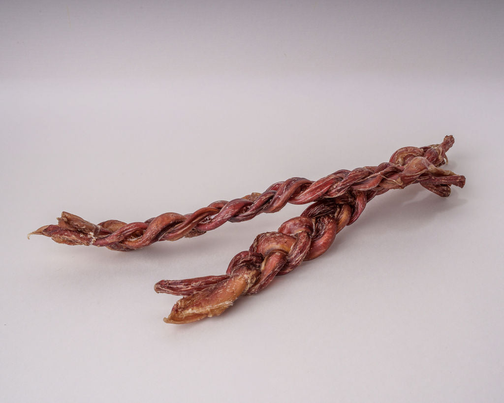 Two braided veal bully sticks on a grey background