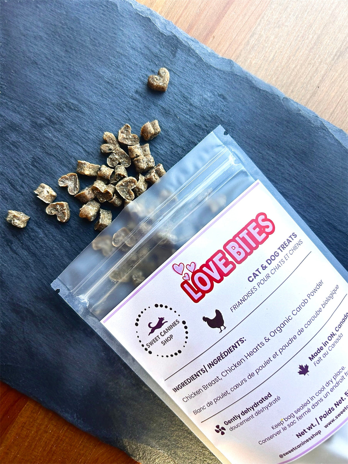 Heart cat treats coming out of clear bag with pink label that says "love bites"