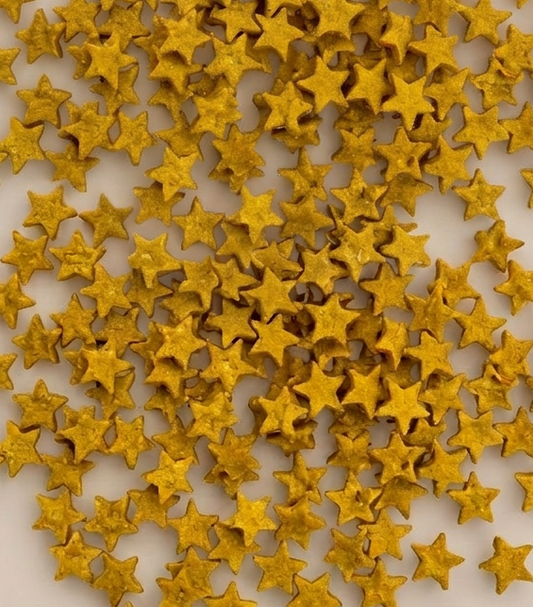 A dense arrangement of small metallic gold star-shaped embellishments scattered across a plain light background.