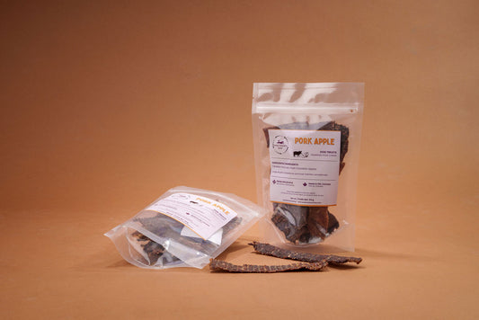 Pouches of dried pork and apples on a brown background
